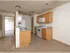 Kitchen with oak cabinets, white appliances, and pass-through counter space, opening into the hallway and living area.