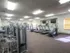On-site fitness center with treadmills, weight machines, and mounted TVs at Oak Court Apartments.