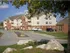 Oak Court community parking area with landscaped medians and multi-building view under a bright sky.