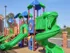 Colorful playground with green spiral slide, red support poles, and blue shade canopies, located at Embassy Ozark Apartments.