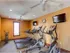 On-site fitness center with treadmills, ellipticals, ceiling fans, and mounted TVs at Embassy Ozark.