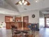 Cozy seating area with round wooden table and view of kitchen cabinetry inside the Embassy Ozark clubhouse.