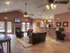 Warm and inviting clubhouse lounge with fireplace, armchairs, and kitchen area at Embassy Ozark