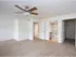 Large bedroom with ceiling fan and plush carpet, leading to an attached bathroom, ideal for comfort and convenience at Willow Creek Apartments.