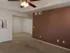 Spacious living room at Willow Creek Apartments featuring neutral tones, ceiling fan, and a double door closet entrance in the dining area.