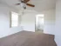 Spacious bedroom at Willow Creek Apartments with large windows, ceiling fan, and direct access to a private bathroom.