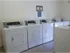 Community laundry room at Willow Creek Apartments featuring multiple commercial-grade washers and dryers for resident use.