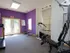 Bright fitness center with strength training equipment and colorful accent wall, located at Willow Creek Apartments in Springfield, MO.