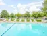 Outdoor pool area at Willow Creek Apartments lined with white lounge chairs, perfect for relaxing under the sun.