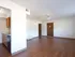 Spacious unfurnished living room with hardwood flooring, ceiling fan, and multiple doorways&mdash;bright and ready for personalization.
