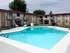 Outdoor swimming pool surrounded by lounge chairs and two-story brick apartment buildings at English Village.