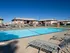Poolside view showing metal loungers and multiple low-rise apartment buildings in the background at English Village.