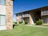 Two-story apartment building with brick exterior, open breezeways, and well-maintained lawn.