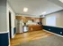Modern clubhouse kitchen with stainless steel appliances, wooden cabinets, and wood-look flooring at English Village.