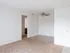 Open living space with plush carpet, white walls, and ceiling fan at English Village Apartments.