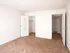 Bright bedroom featuring an open closet and hallway view, accented by soft carpet and natural light.