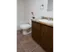 Clean bathroom with tiled flooring, a single-sink wood vanity, and a standard tub and toilet setup.