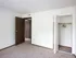 Cozy bedroom with two-tone closet and entry doors, white walls, and neutral carpet flooring.