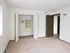 Bedroom with wide double-door closet, soft carpet, and view into hallway at English Village Apartments.