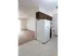 Compact kitchen with white appliances and dark cabinets, opening into a carpeted living area.