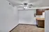 Small dining area with ceiling fan, tiled floors, and dark wood kitchen cabinetry at English Village Apartments.