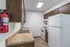 Galley-style kitchen with white appliances, wood cabinets, and laminate countertops at English Village Apartments.