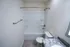 A bathroom with a white toilet and bathtub, brushed nickel fixtures, and a granite-style vanity with sink and mirror.