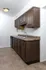 Updated kitchen at Timbers Apartments with dark wood cabinets, dual-basin sink, and neutral tile flooring.