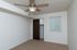 Bright, empty bedroom featuring a ceiling fan, beige carpet, a closet with double doors, and a window with blinds.