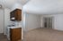 Cozy open floor plan featuring a kitchen area with dark wood cabinets and a spacious living room with sliding doors to a patio.