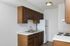 Kitchen at Timbers Apartments in downtown Springfield, MO, featuring upper and lower wood cabinets and white appliances.