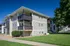 Exterior view of Timbers Apartments near MSU, showcasing the building's clean siding and private balconies.