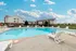 Outdoor swimming pool at Oak Court Apartments in Republic, MO, with lounge chairs and scenic apartment buildings in the background.