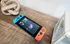 Close-up of a Nintendo Switch in the Republic Palms clubhouse displayed on a rustic wooden tabletop next to home decor, emphasizing the resident-friendly, entertainment-focused amenities.