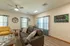Corner view of the Republic Palms community room showing a gray sofa, bright windows with teal curtains, and artwork that enhances the welcoming atmosphere.