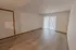 Spacious living room in a 1-bedroom Polo Club apartment with wood-style flooring, neutral walls, and large sliding glass doors allowing natural light to fill the room.