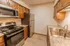 Modern kitchen in a Polo Club 1-bedroom apartment featuring stainless steel appliances, granite-style countertops, and wood cabinetry.