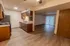 Open concept kitchen and living room in Polo Club apartments with wood-style flooring, granite-style countertops, and a ceiling fan.