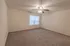 Spacious bedroom in a Polo Club 1-bedroom apartment featuring plush carpet flooring, a ceiling fan, and a large window for natural light.