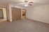 Bedroom in Polo Club apartments with double-door closets, plush carpeting, and a doorway leading to a private bathroom.