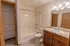 Bathroom in Polo Club apartments with a bathtub and shower combo, granite-style countertops, a wide vanity mirror, and built-in shelving.