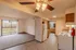 A galley-style kitchen with a double sink and ample counter space. The view extends into the living room, featuring a balcony with natural light.