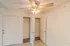 Entryway with two separate closets, one featuring wire shelving for pantry or utility storage and the other designed for coats, all set beside the main front door under a ceiling fan.