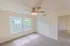 Bedroom with double-door closet, ceiling fan, and large window, connected to the main living space and ideal for a queen or king-size bed layout.