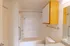 Vanity view of the bathroom with a single sink, wooden cabinetry, and wall-mounted mirror, offering a clean and functional design.
