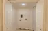 Dedicated laundry room with washer and dryer hookups, overhead wire shelving, and tile flooring for easy maintenance.