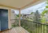 Private balcony view overlooking the pool area, complete with lounge chairs, umbrellas, and mature landscaping below.