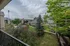 Scenic perspective from the balcony capturing manicured lawns, tree-lined pathways, and outdoor amenities within Cobblestone Village.