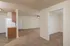 Open-concept living space with plush carpet, adjacent kitchen, and ceiling fan at Embassy Ozark.