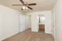 Bedroom with walk-in closet, carpet flooring, ceiling fan, and direct access to bathroom vanity at Embassy Ozark.
